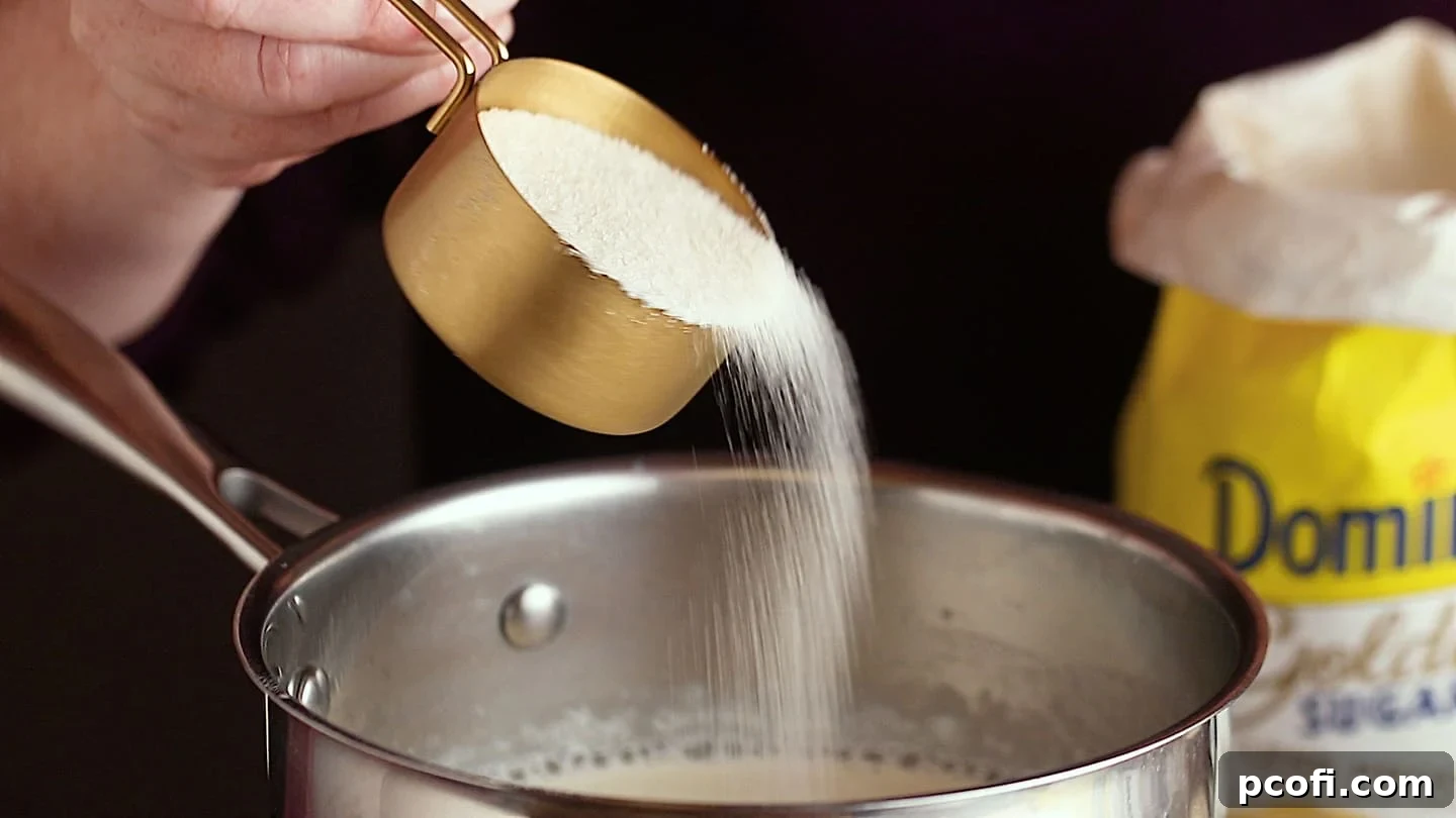 Making panna cotta: Sprinkling sugar into the pot.