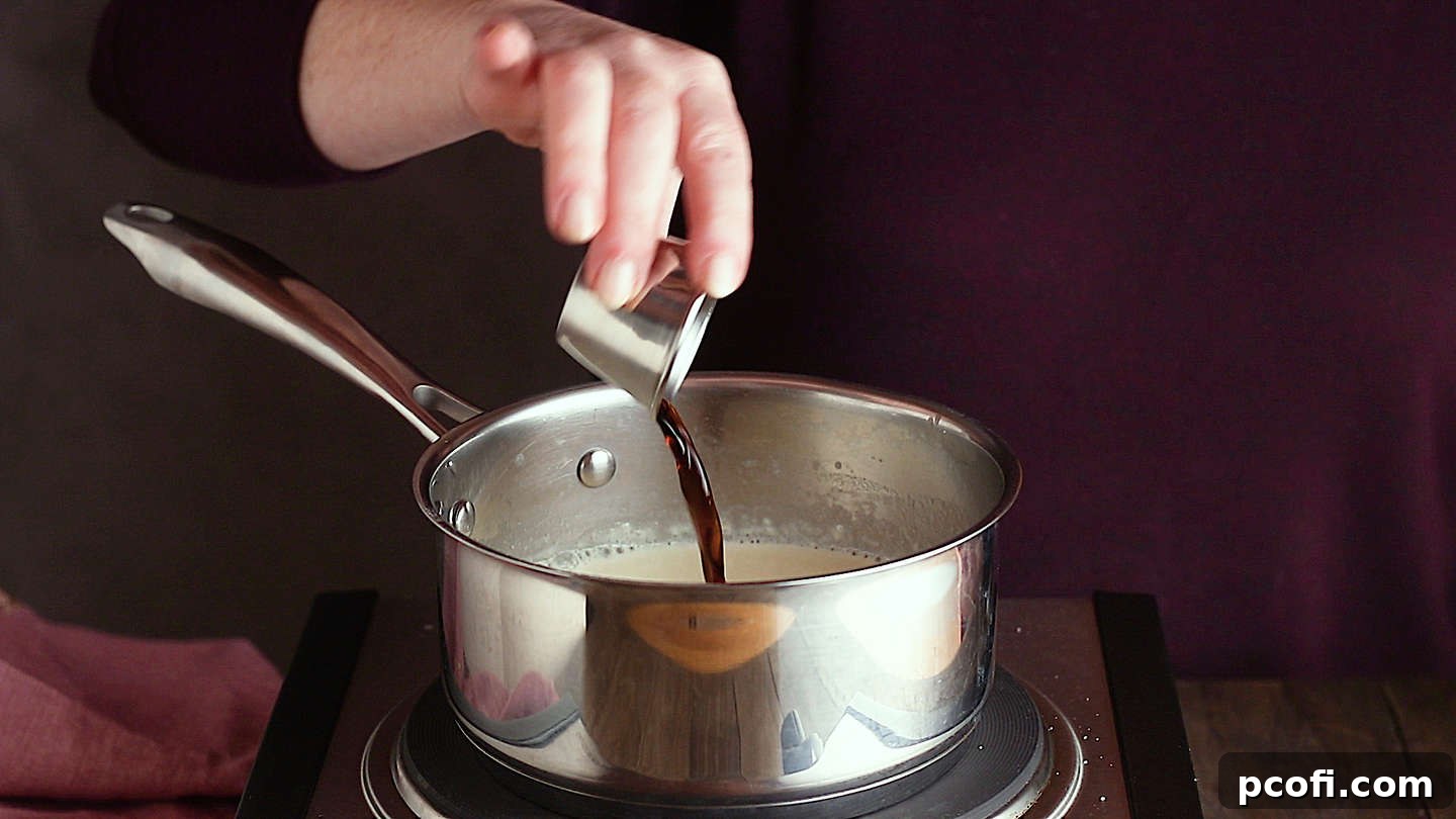 Making panna cotta: Adding vanilla extract.
