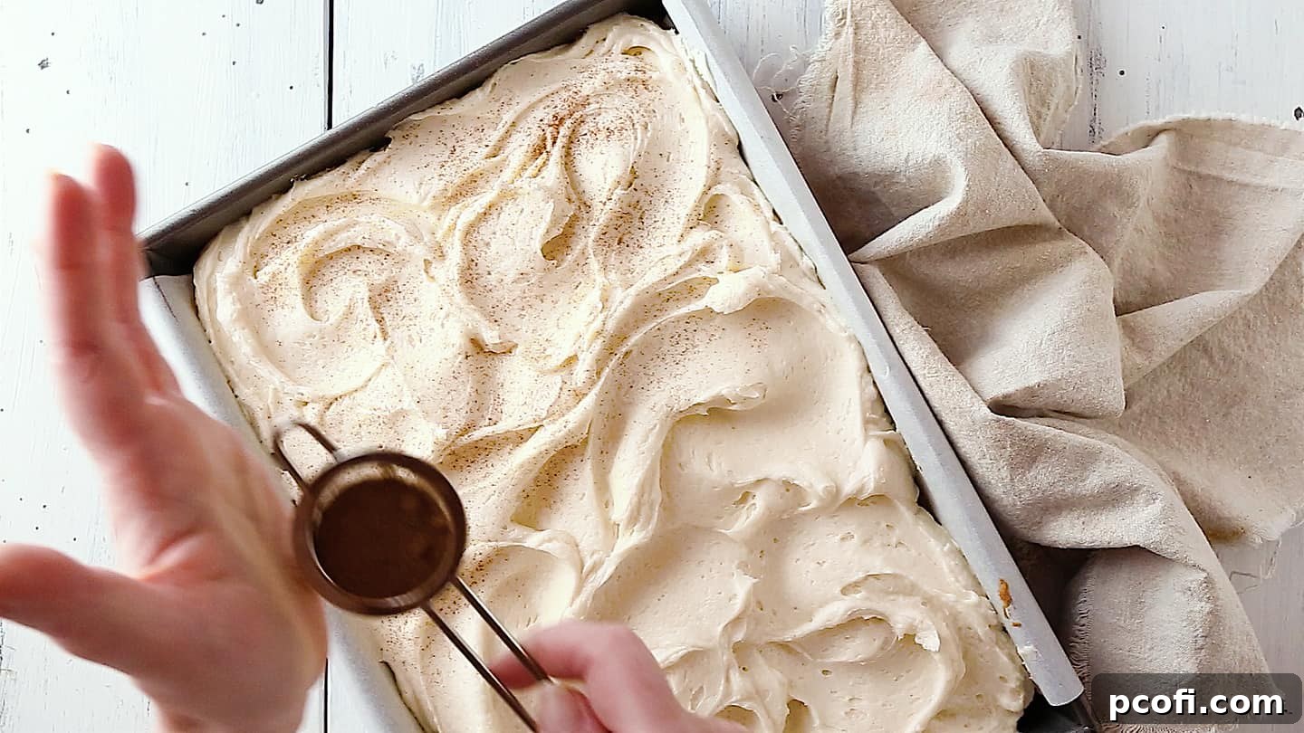 Dusting pumpkin cake with a sprinkle of cinnamon.