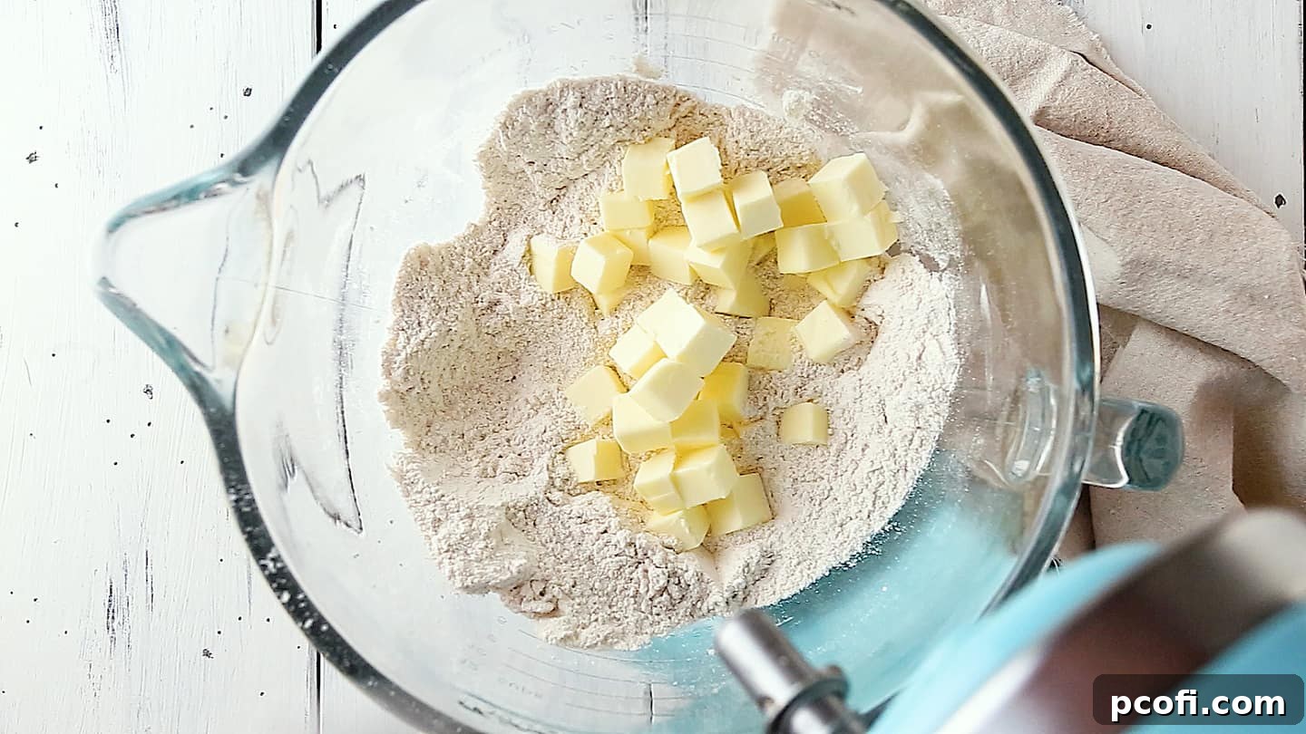 Adding butter to dry ingredients for pumpkin cake.