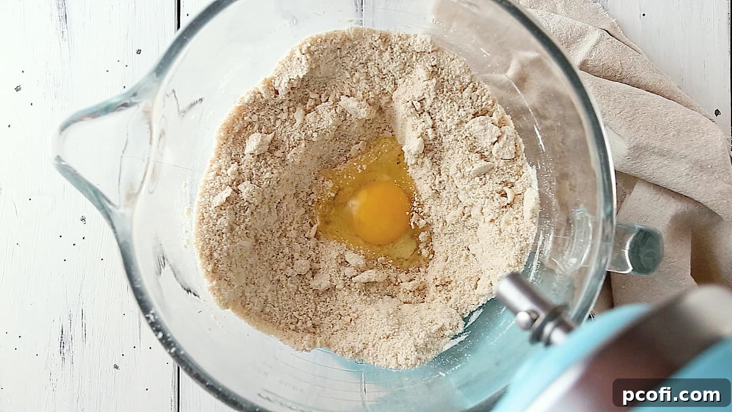 Adding eggs to pumpkin cake batter.