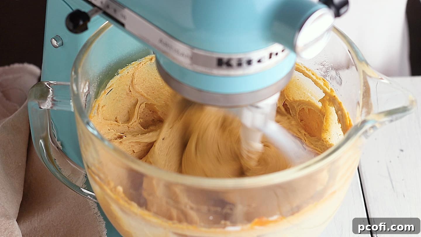 Mixing pumpkin cake batter in a stand mixer.
