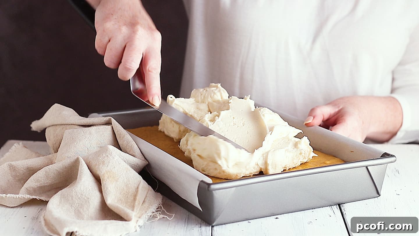Frosting pumpkin cake with cream cheese icing.