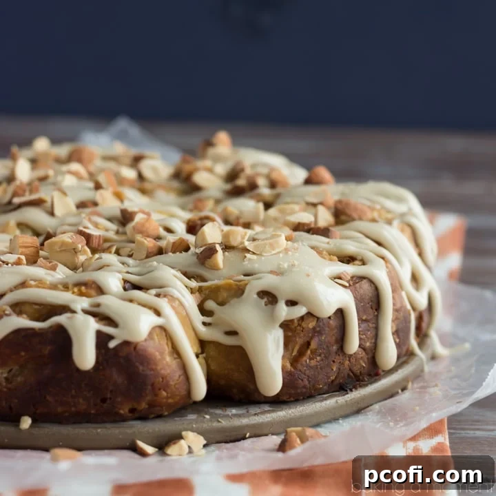 Fluffy buttermilk angel biscuits filled with sweet and savory bacon and dates, drizzled with a rich maple glaze and topped with crunchy toasted almonds, perfect for any occasion.