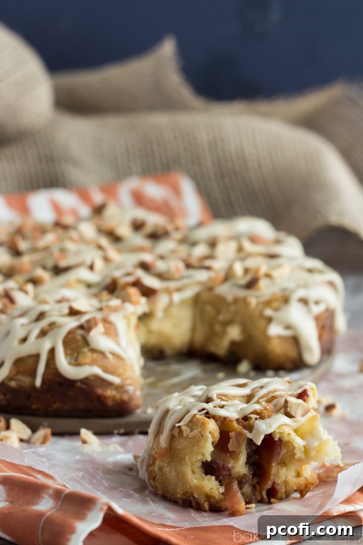 A plate of warm Bacon and Date Angel Biscuits with maple glaze and toasted almonds, beautifully arranged and ready to be enjoyed.