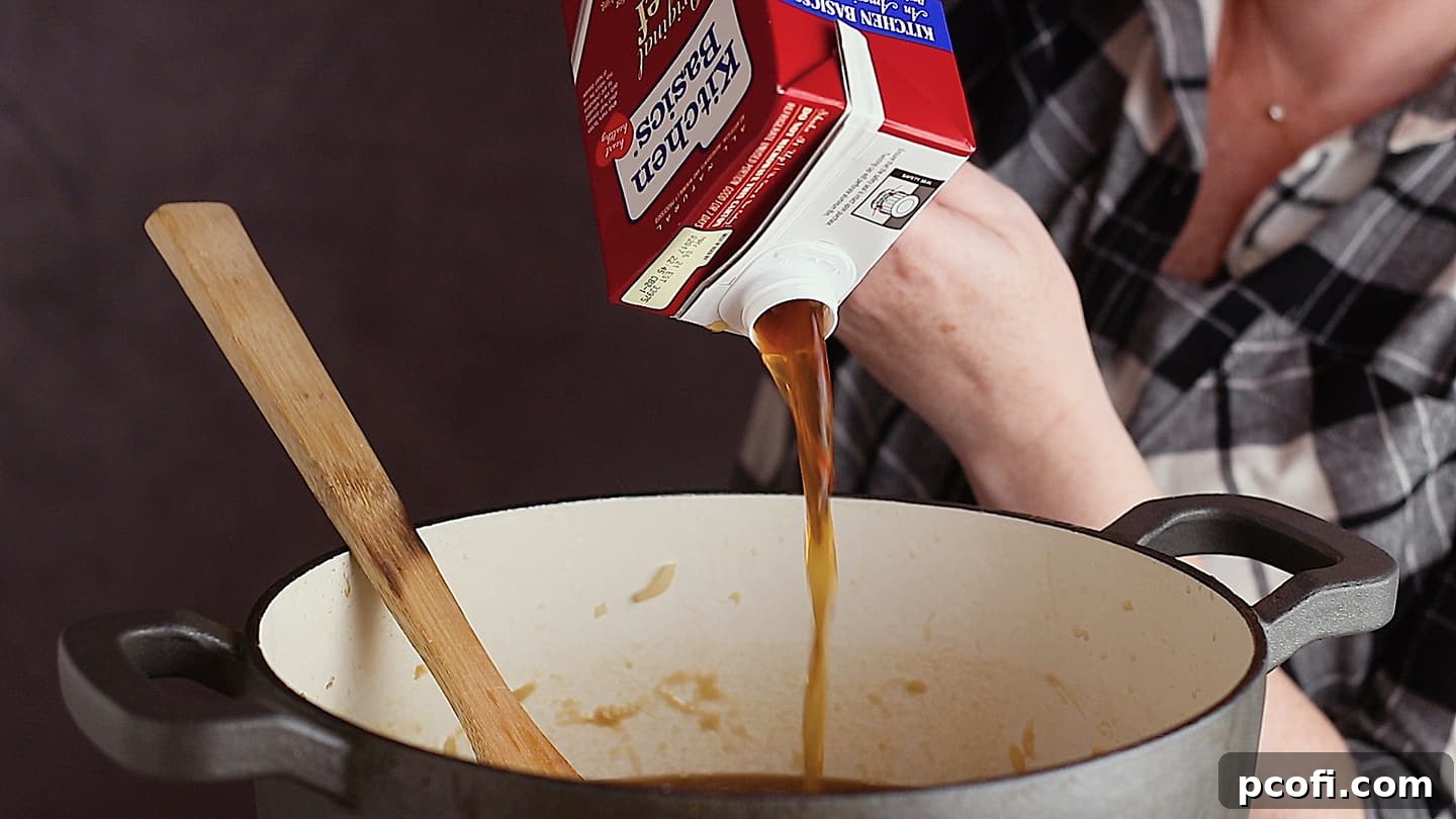 Pouring beef stock into caramelized onions for French onion soup.
