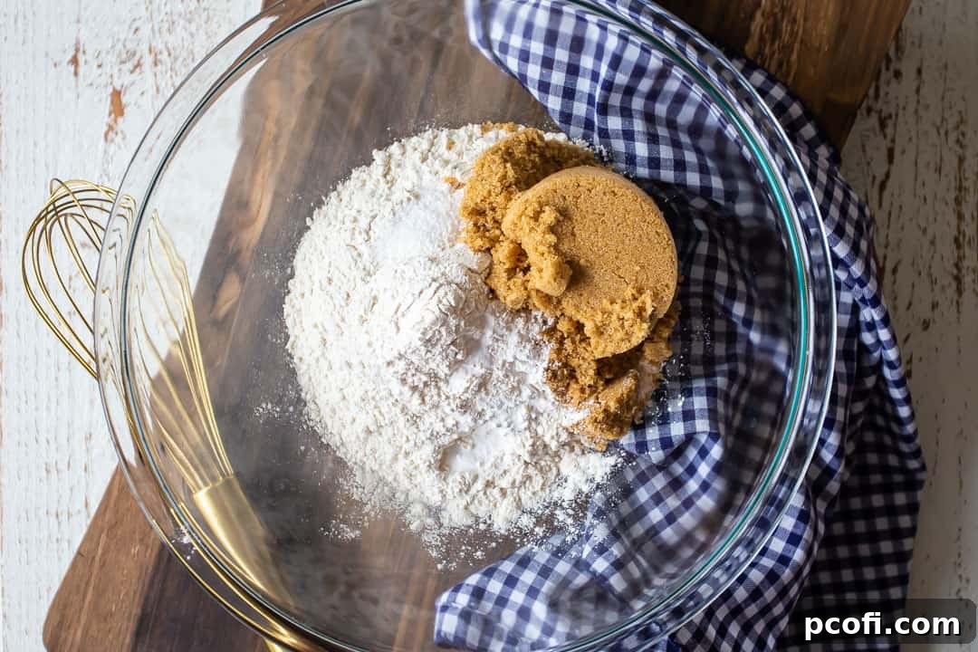 Dry ingredients for the homemade pumpkin gooey butter cake base in a clear glass bowl, showcasing the simplicity of from-scratch baking.