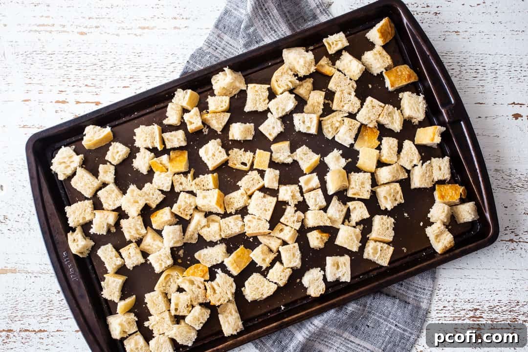 Dry cubes of bread on a baking sheet.
