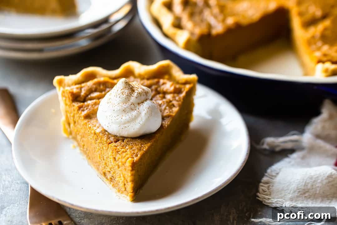 A close-up of a delectable slice of Southern sweet potato pie in the foreground, with the whole golden-brown pie and additional serving plates artfully blurred in the background.