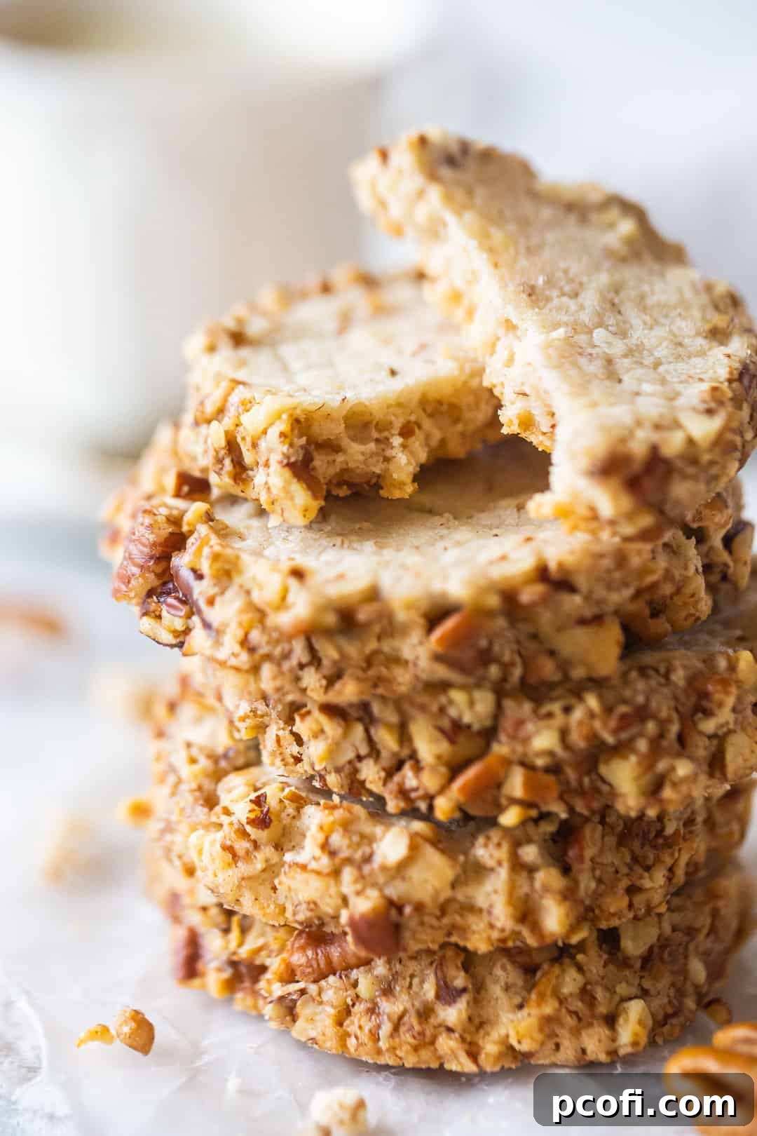 A beautiful stack of freshly baked pecan sandies cookies, showcasing their golden edges and rich pecan texture.