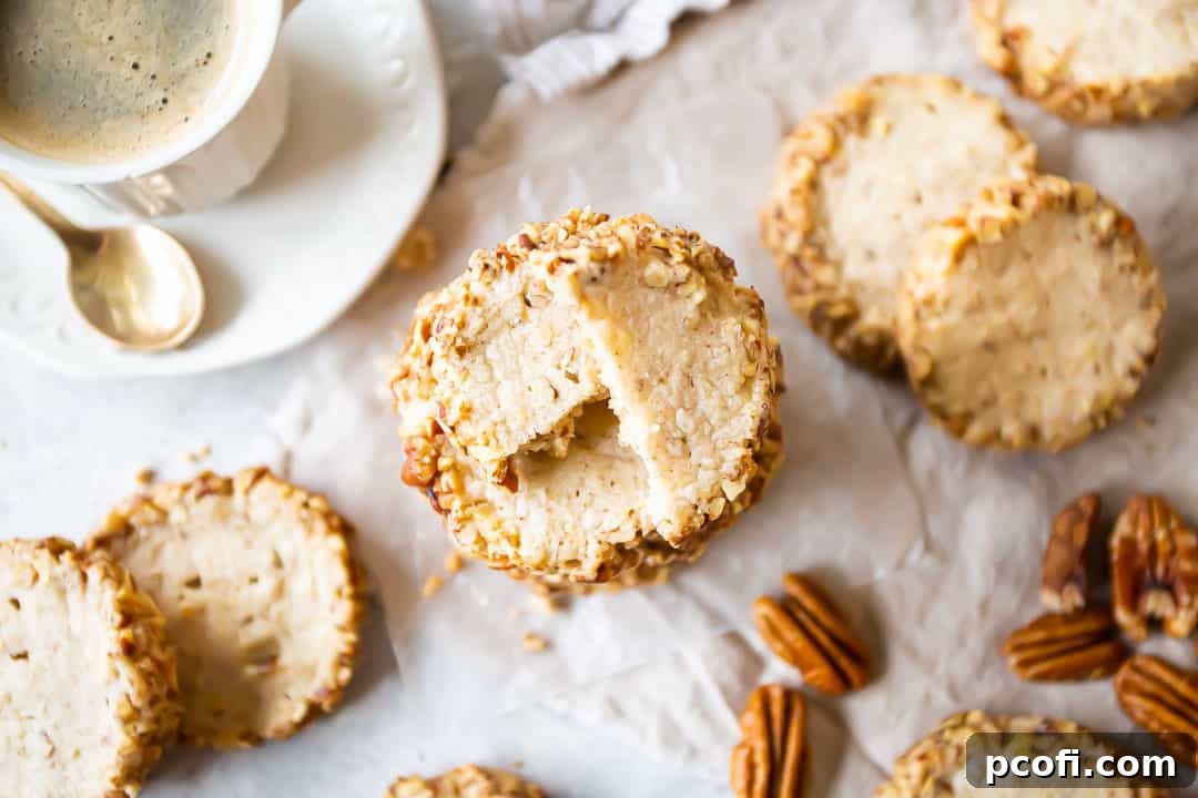 Overhead image of homemade Keebler-style pecan sandies with whole pecans and a comforting cup of coffee in a white porcelain cup.