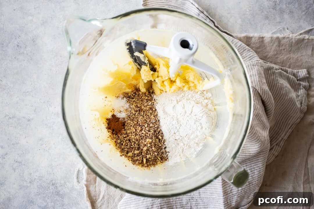 Finely ground pecans, all-purpose flour, a hint of cinnamon, and salt are added to the wet ingredients for pecan sandies cookie dough.