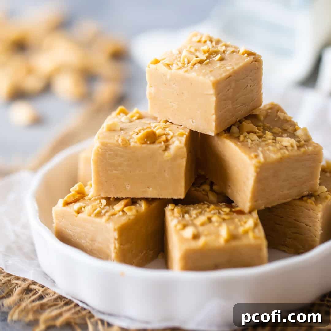 Creamy peanut butter fudge cut into perfect squares, arranged invitingly on a white plate, ready to be enjoyed.