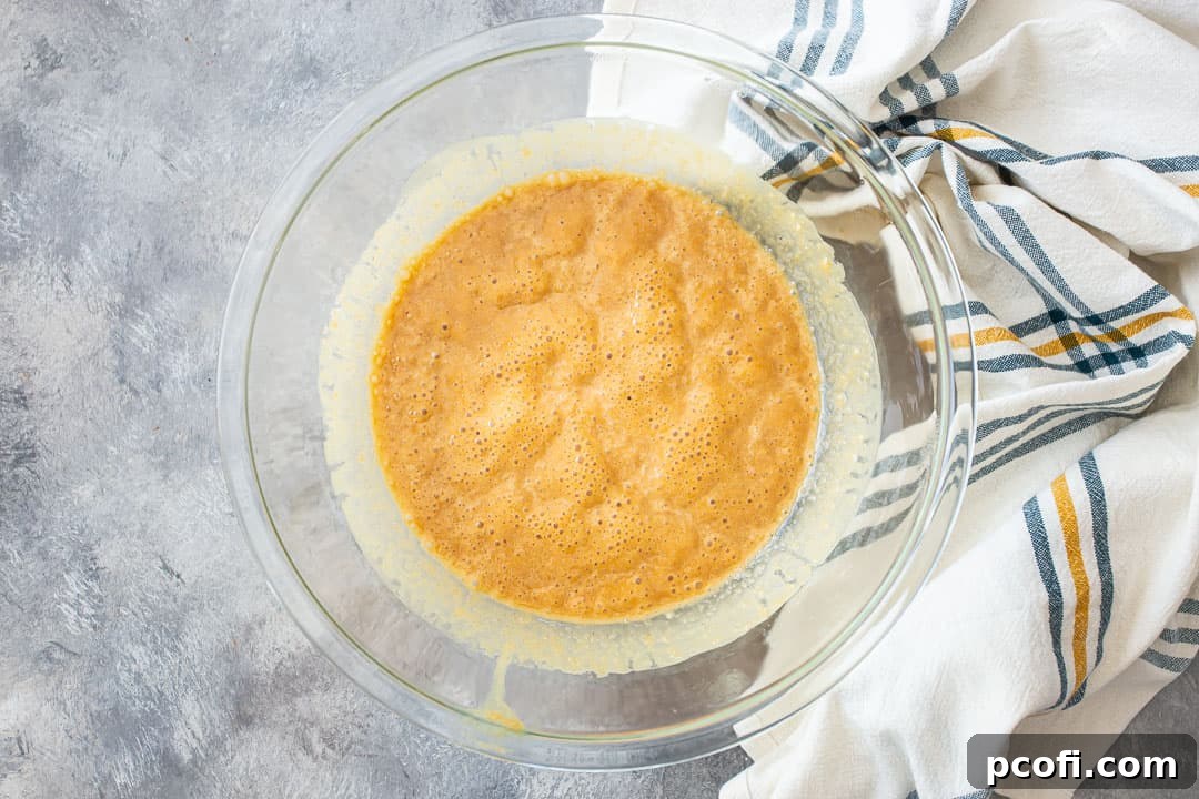 Peanut butter, butter, and salt boiling together in a large glass mixing bowl after microwaving, ready for sugar.
