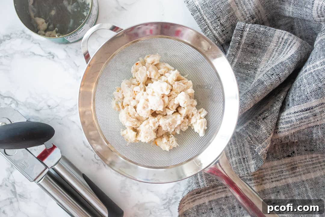 Drained & rinsed canned crab meat in a fine mesh strainer.