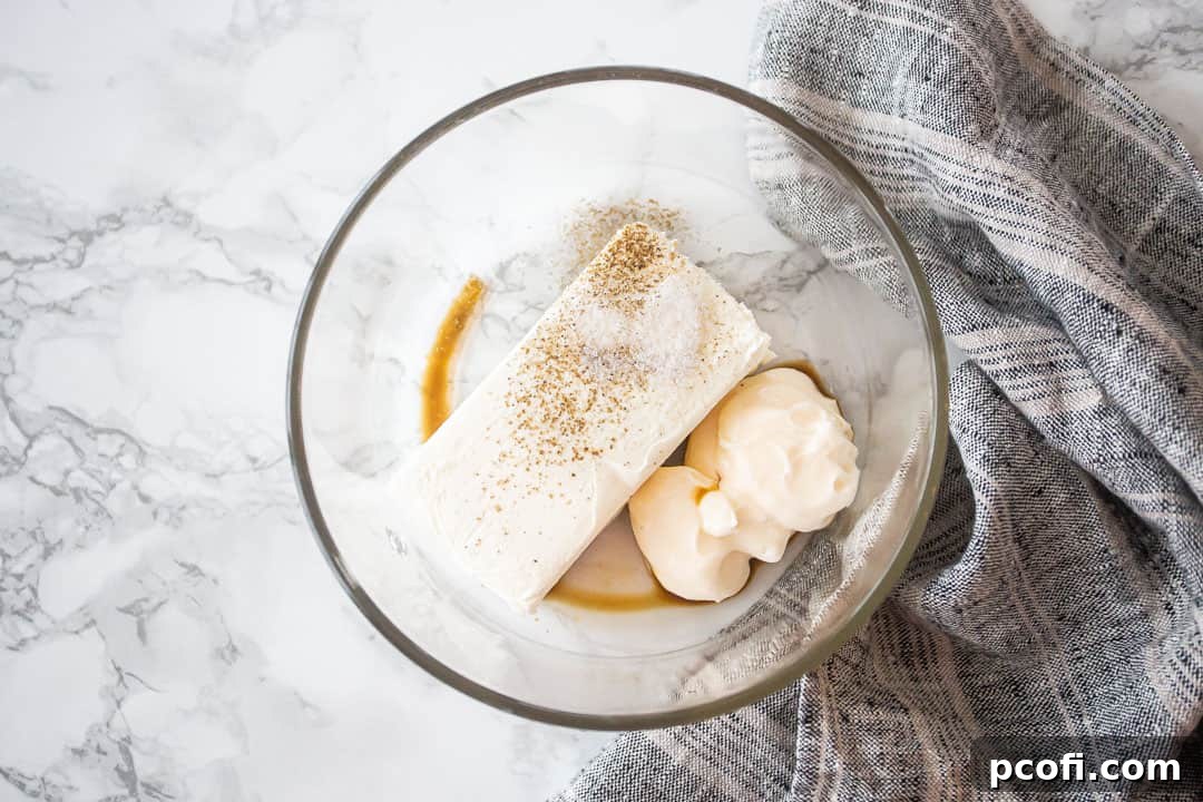Cream cheese, mayo, & seasonings in a bowl for making crab dip.