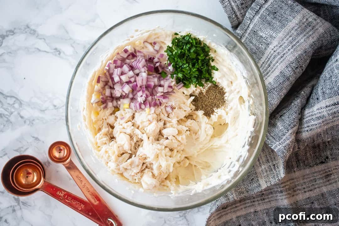 Making cold crab dip with onion, parsley, and celery seed.