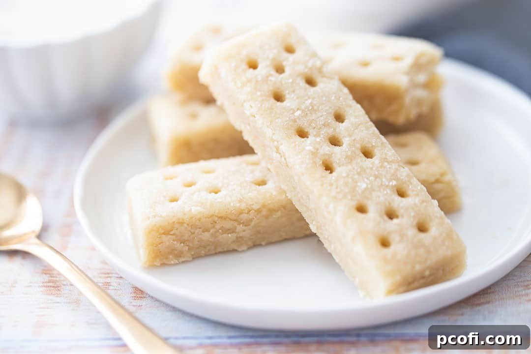 The best shortbread cookie recipe served elegantly on a white plate with a decorative sugar bowl in the background, ready for enjoyment.