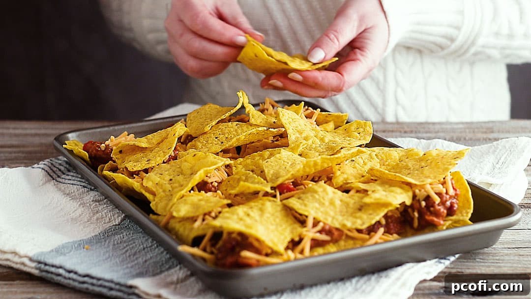 Adding a second layer of tortilla chips to nachos recipe.