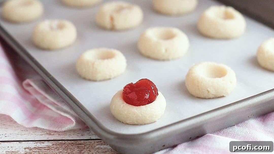 Unbaked thumbprint cookies filled with jam.