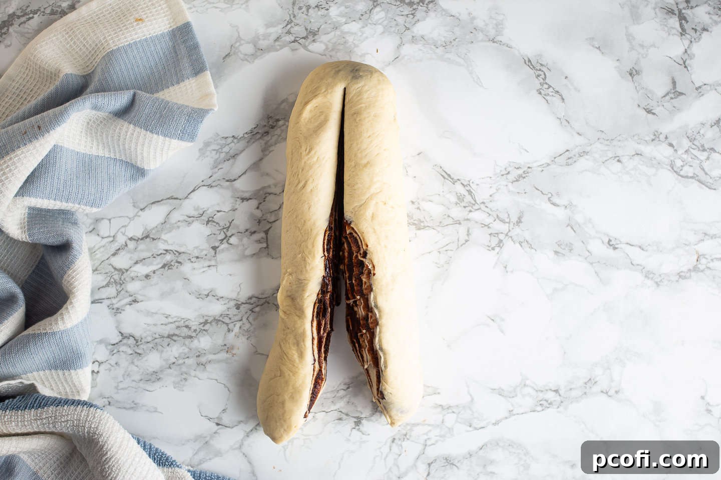 Cutting babka log in half lengthwise.