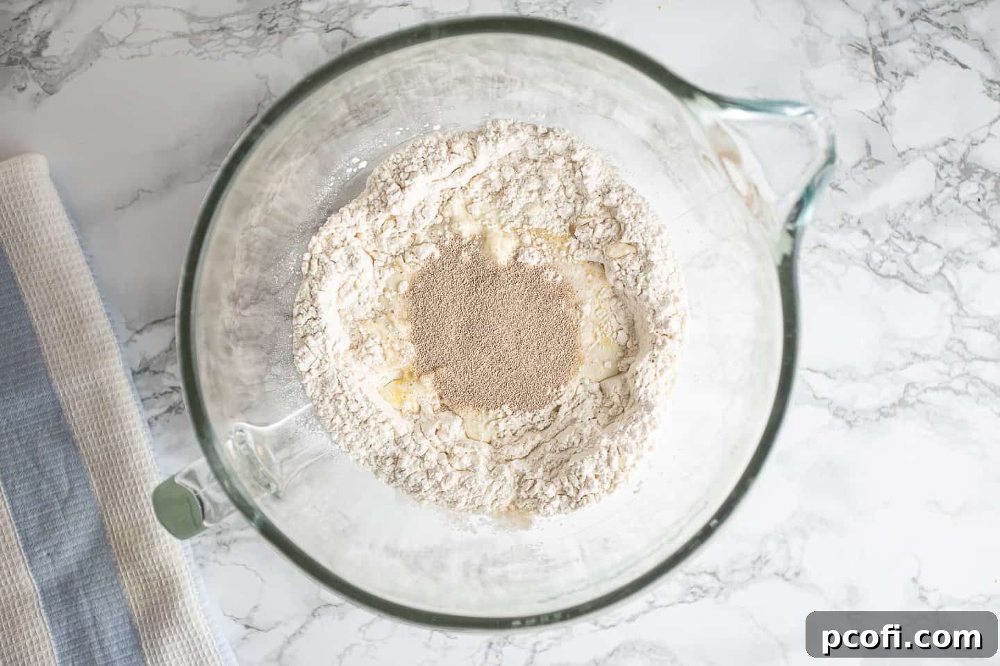 Dissolving yeast in a well of liquid in the center of the dry ingredients needed for chocolate babka.