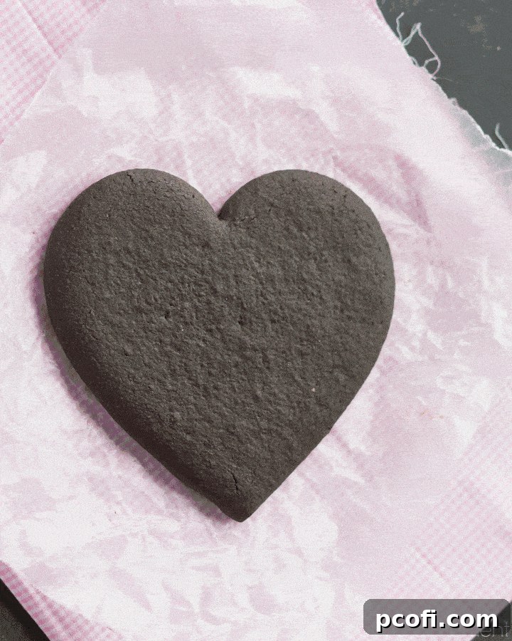 Step-by-step assembly of a cookie gift box, showing layers of heart-shaped cookies stacked with icing.