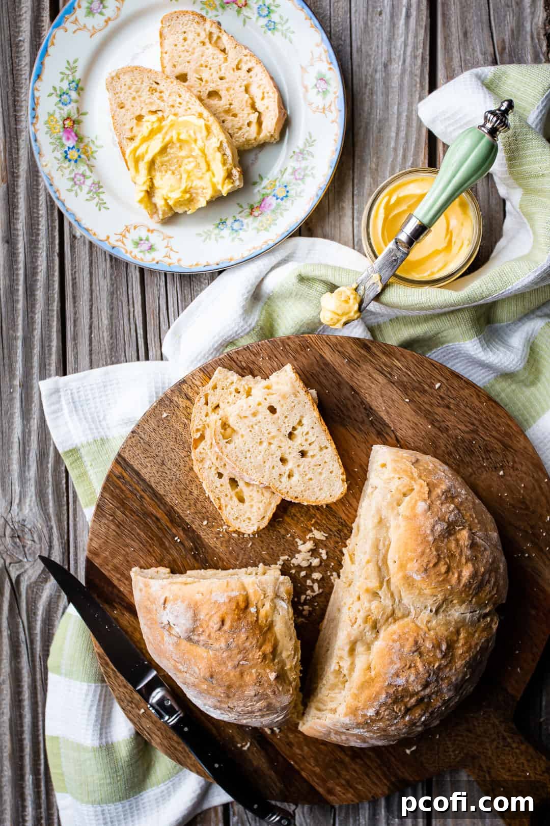 Overhead image of Irish soda bread recipe, prepared and served on a board with a green striped cloth.