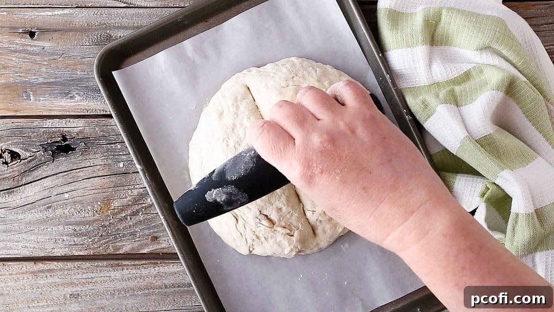 Scoring Irish soda bread in a criss-cross pattern.