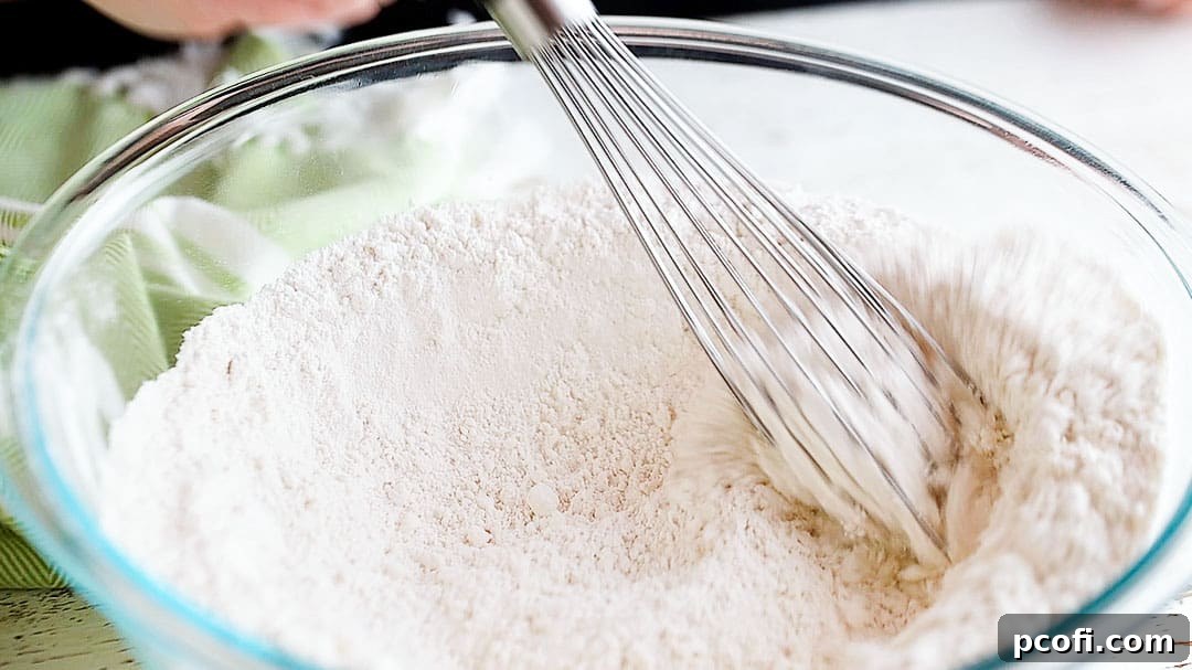 Whisking dry ingredients together to make Irish scones in a large bowl.