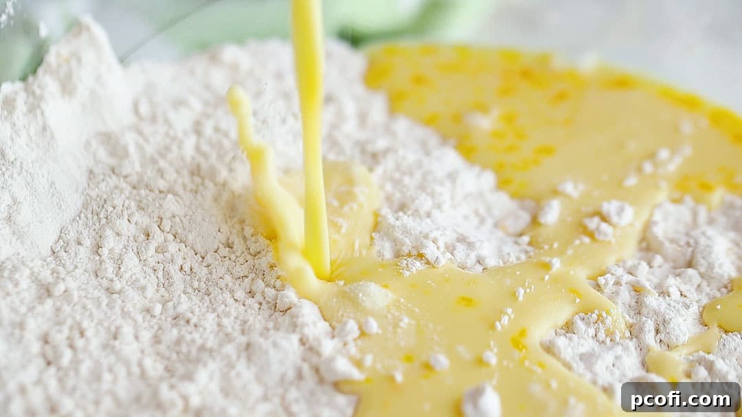 Pouring wet ingredients (milk and eggs) into dry ingredients for scone mixture.