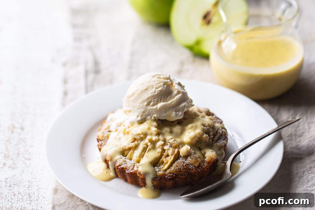 French apple tart served warm with a creamy custard sauce and a scoop of cold vanilla ice cream.