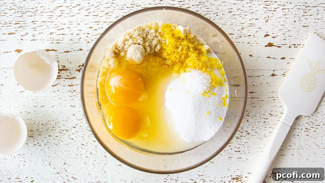 Frangipane ingredients meticulously arranged in a clear glass mixing bowl, ready to be combined for the apple tart filling.
