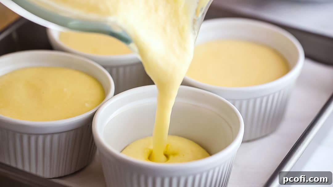 Pouring lemon pudding cake batter into individual ramekins.