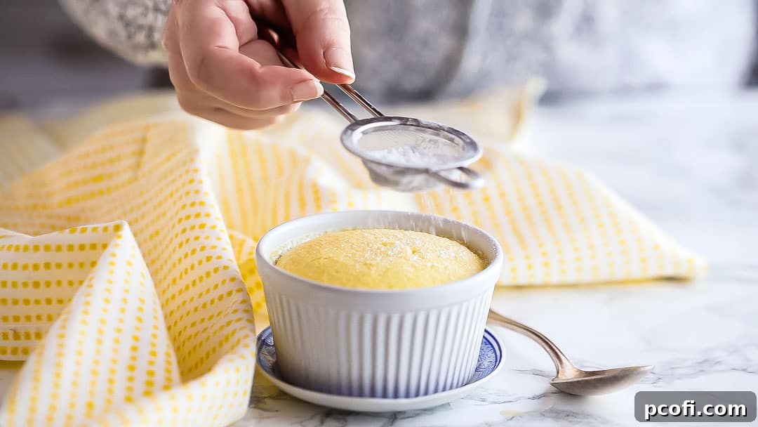Dusting a warm lemon pudding cake with powdered sugar as a simple garnish.