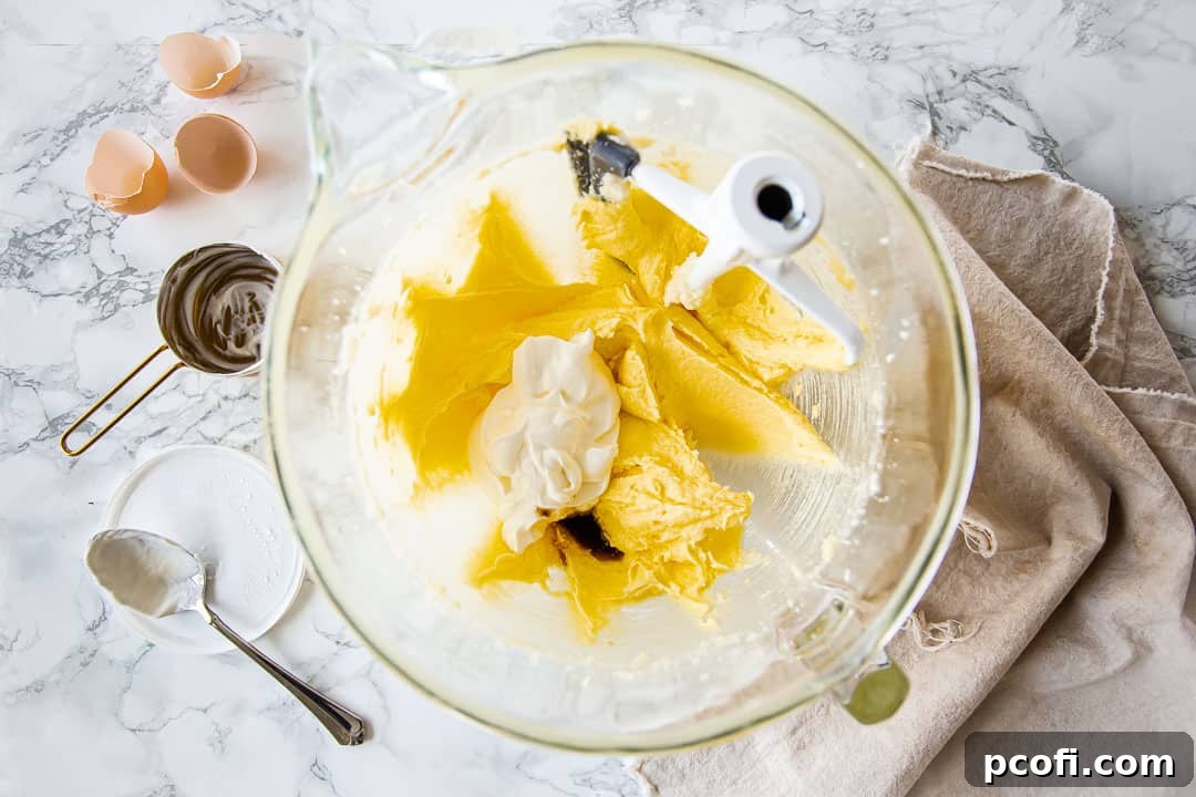 Adding sour cream to chocolate pound cake batter.
