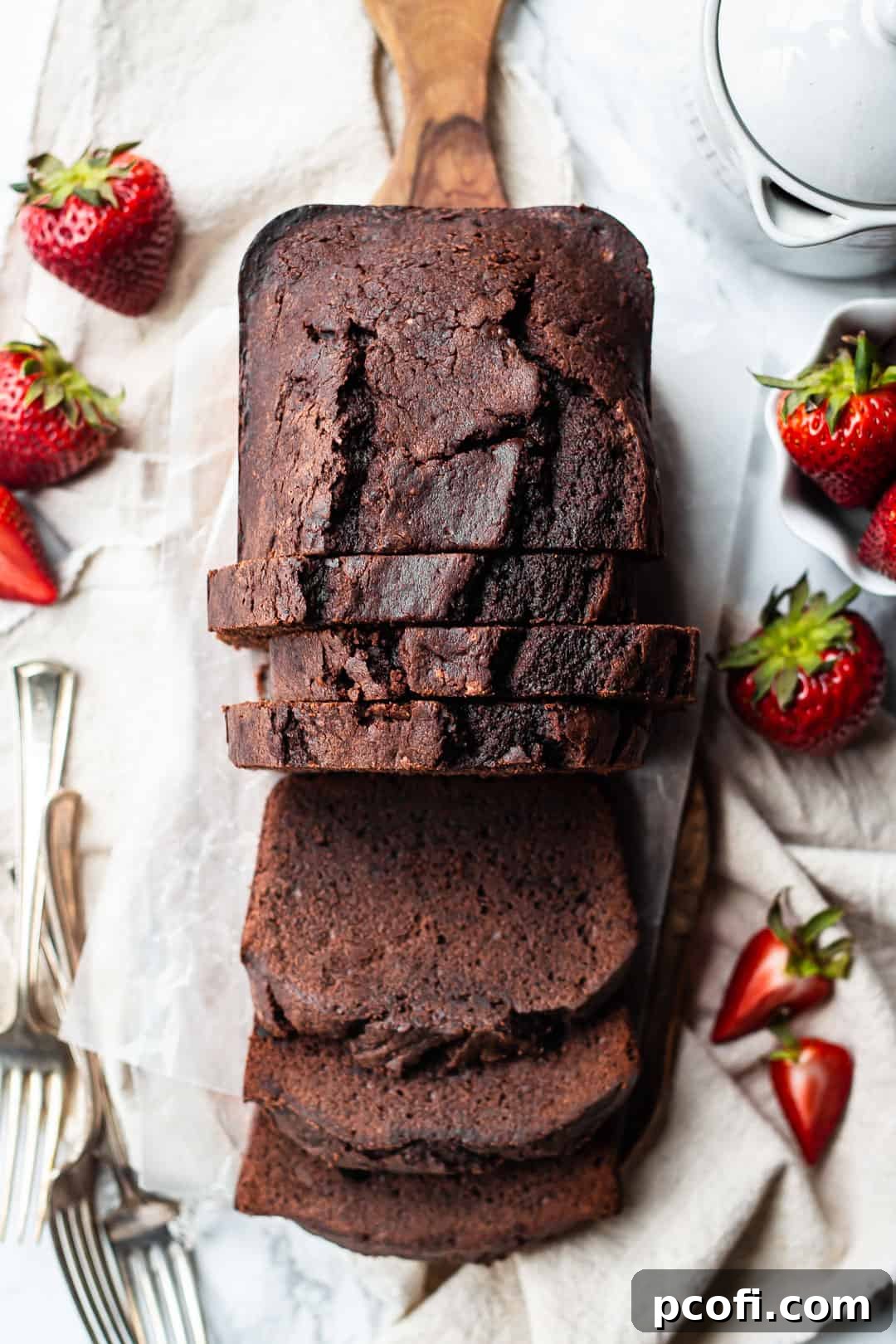 Overhead image of a dark chocolate sour cream pound cake sliced and served on a board.