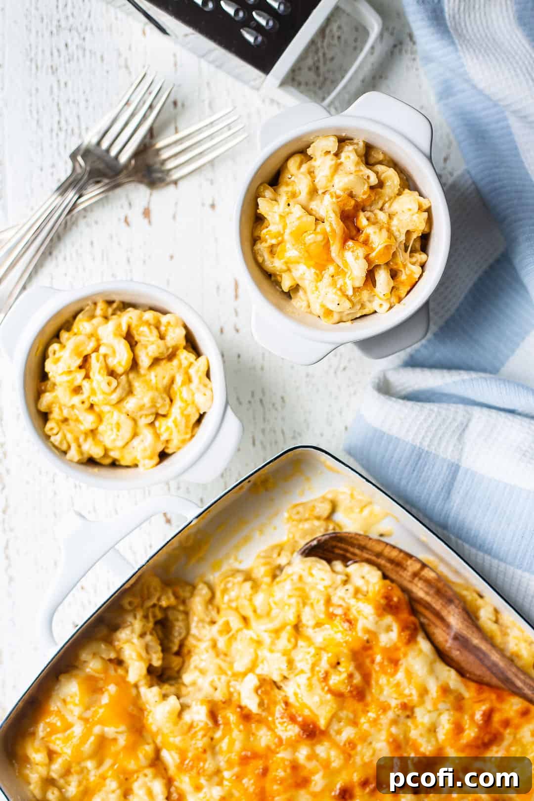 Overhead view of several individual bowls filled with warm, creamy baked macaroni and cheese, freshly spooned from the casserole dish.