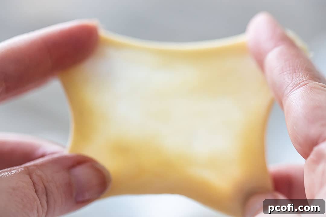 Performing the windowpane test on yeast dough, stretching it thin enough to see through.
