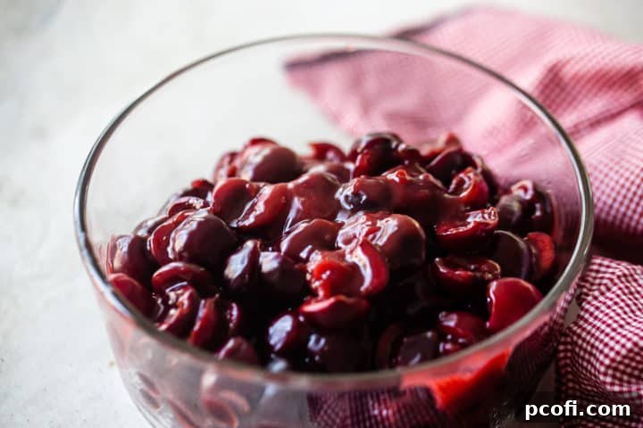 Stovetop cherry pie filling, now thick and syrupy, showcased in a clear glass bowl, ready for the pie crust.