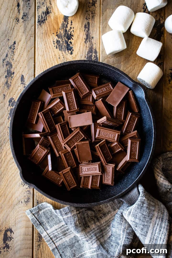 Milk chocolate bars, broken into small pieces and scattered in the bottom of an iron skillet.