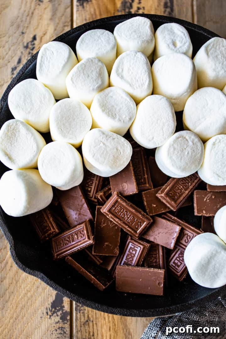 Chocolate pieces in a skillet with marshmallows layered on top.