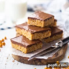 Scotcheroos stacked on a wooden serving board.