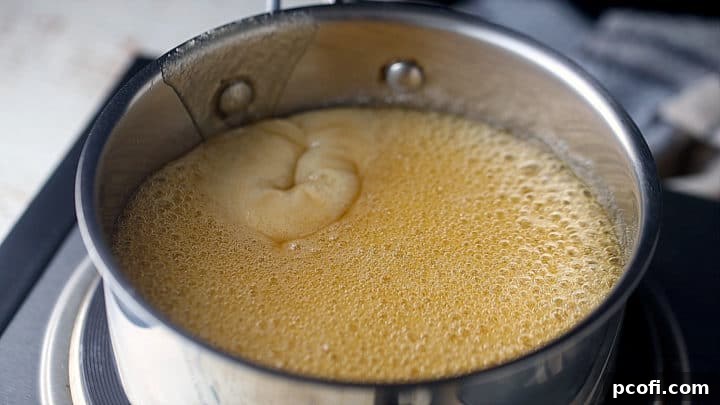 Boiling honey and sugar together in a pot, demonstrating the gentle boil.