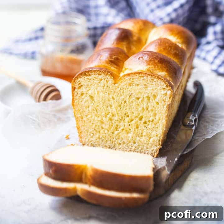 Brioche loaf on a wooden board with a blue checked cloth in the background.