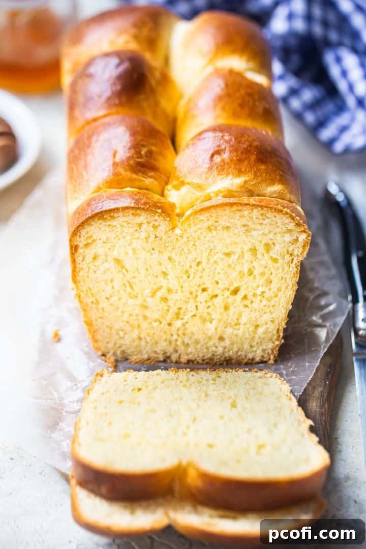 Brioche recipe, prepared, baked, and sliced with a blue checked cloth in the background.
