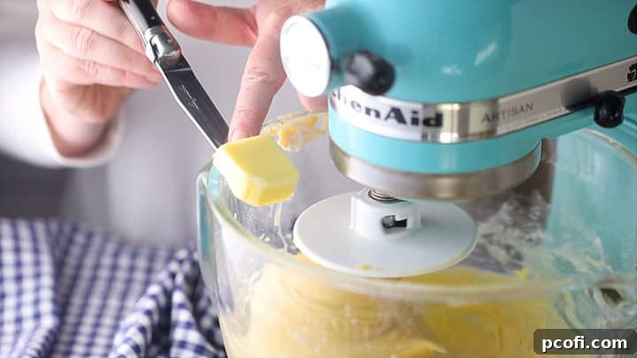 Working soft butter into brioche dough, a tablespoon at a time.