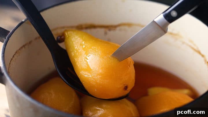 Using a sharp knife to check the doneness of a poached pear, indicating readiness.