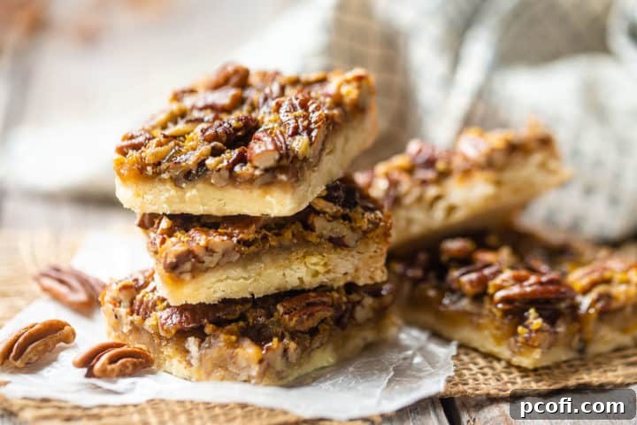 Best pecan pie bars arranged in stacks on burlap squares, with a green checked cloth in the background.