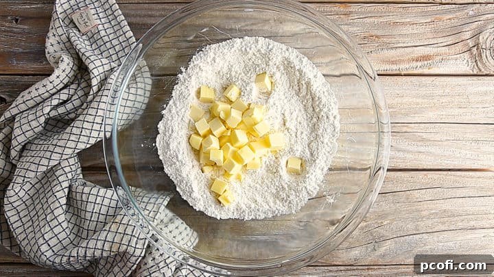 Adding cold, cubed butter to shortbread crust.